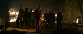 Movie still from “Snake Eyes” (2021), directed by Robert Schwentke – A group of people standing in the middle of a field; Wide shot, Low angle