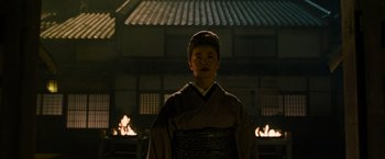Movie still from “Snake Eyes” (2021), directed by Robert Schwentke – A man in a kimono standing in front of a fire pit; Medium shot, Low angle