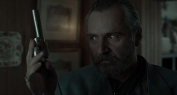 Movie still from “Snatch” (2000), directed by Guy Ritchie – A person holding a gun; Close Up shot, Low angle