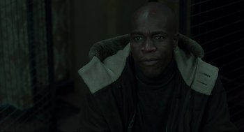 Movie still from “Snatch” (2000), directed by Guy Ritchie – A man in a brown jacket is looking at the camera; Close Up shot, High angle