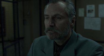 Movie still from “Snatch” (2000), directed by Guy Ritchie – An older man wearing a suit and a tie; Close Up shot, Over the shoulder angle
