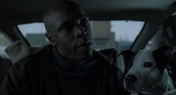 Movie still from “Snatch” (2000), directed by Guy Ritchie – A man and a dog in a dark room; Close Up shot, Low angle