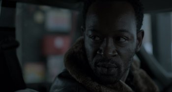 Movie still from “Snatch” (2000), directed by Guy Ritchie – A person wearing a jacket; Close Up shot, Over the shoulder angle
