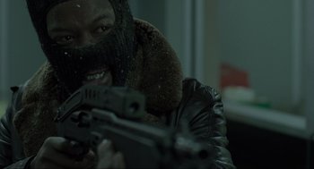 Movie still from “Snatch” (2000), directed by Guy Ritchie – A man with a gun in his hands; Close Up shot, Low angle