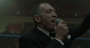 Movie still from “Snatch” (2000), directed by Guy Ritchie – A person holding a microphone; Close Up shot, Low angle