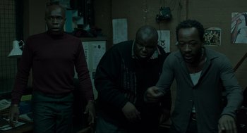 Movie still from “Snatch” (2000), directed by Guy Ritchie – A group of men standing next to each other in a room; Medium shot, High angle