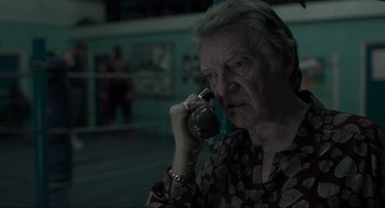 Movie still from “Snatch” (2000), directed by Guy Ritchie – An older man talking on a cell phone; Close Up shot, Low angle