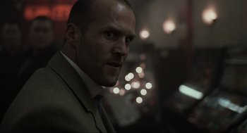 Movie still from “Snatch” (2000), directed by Guy Ritchie – A person wearing a suit and tie; Close Up shot, Low angle