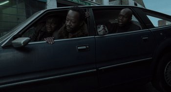 Movie still from “Snatch” (2000), directed by Guy Ritchie – A group of people sitting in the back of a car; Close Up shot, Low angle