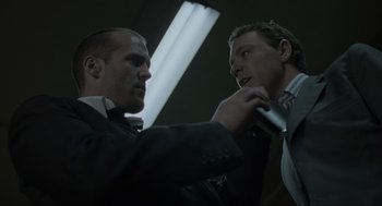 Movie still from “Snatch” (2000), directed by Guy Ritchie – Two men in suits and ties are looking at each other; Close Up shot, Low angle