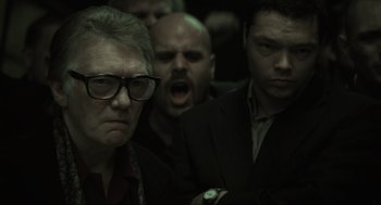 Movie still from “Snatch” (2000), directed by Guy Ritchie – A group of people in a dark room; Close Up shot, Low angle
