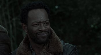 Movie still from “Snatch” (2000), directed by Guy Ritchie – A person with a beard smiling; Close Up shot, Over the shoulder angle