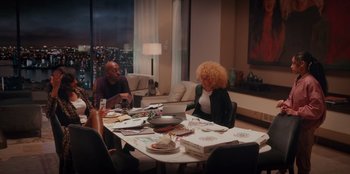 Movie still from “Sneakerella” (2022), directed by Elizabeth Allen Rosenbaum – A group of people sitting around a table; Wide shot, High angle