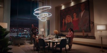 Movie still from “Sneakerella” (2022), directed by Elizabeth Allen Rosenbaum – A group of people sitting around a table in a room; Extreme Wide shot, High angle