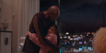 Movie still from “Sneakerella” (2022), directed by Elizabeth Allen Rosenbaum – A man and a woman hugging in front of a city skyline at night; Medium shot, Over the shoulder angle