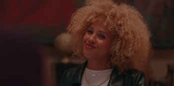 Movie still from “Sneakerella” (2022), directed by Elizabeth Allen Rosenbaum – A person wearing a jacket with curly hair; Close Up shot, Over the shoulder angle