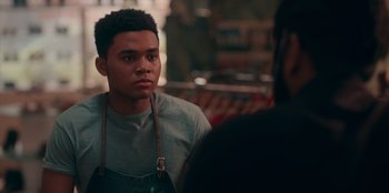 Movie still from “Sneakerella” (2022), directed by Elizabeth Allen Rosenbaum – A young man in an overalls is looking at the camera; Close Up shot, Over the shoulder angle