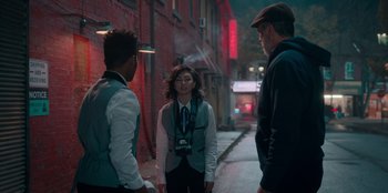 Movie still from “Sneakerella” (2022), directed by Elizabeth Allen Rosenbaum – A group of people standing on the side of a street; Medium shot, Over the shoulder angle