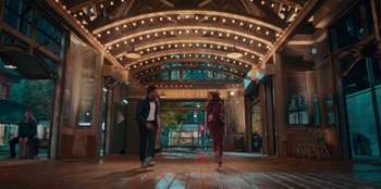 Movie still from “Sneakerella” (2022), directed by Elizabeth Allen Rosenbaum – Two people are walking down the hall of a theater; Wide shot, Low angle