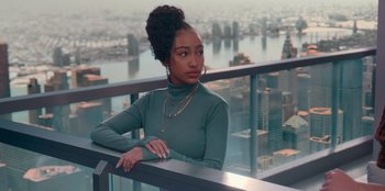 Movie still from “Sneakerella” (2022), directed by Elizabeth Allen Rosenbaum – A woman in a green shirt is standing on a balcony; Medium shot, Low angle