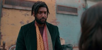Movie still from “Sneakerella” (2022), directed by Elizabeth Allen Rosenbaum – A man with dreads wearing a green jacket; Medium shot, Low angle