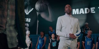 Movie still from “Sneakerella” (2022), directed by Elizabeth Allen Rosenbaum – A group of people standing in front of a basketball hoop; Medium shot, Low angle