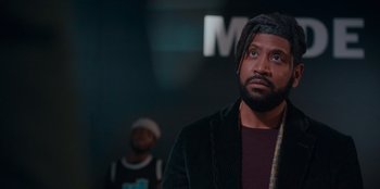 Movie still from “Sneakerella” (2022), directed by Elizabeth Allen Rosenbaum – A man with a beard is looking up; Close Up shot, Over the shoulder angle