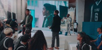 Movie still from “Sneakerella” (2022), directed by Elizabeth Allen Rosenbaum – A group of people standing on a stage; Wide shot, Over the shoulder angle