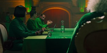 Movie still from “Sniper: G.R.I.T. - Global Response & Intelligence Team” (2023), directed by Oliver Thompson – A man and woman sitting at a table in front of a computer; Medium shot, Over the shoulder angle