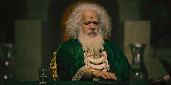 Movie still from “Sniper: G.R.I.T. - Global Response & Intelligence Team” (2023), directed by Oliver Thompson – An old man with white hair and a long white beard; Medium shot, Low angle