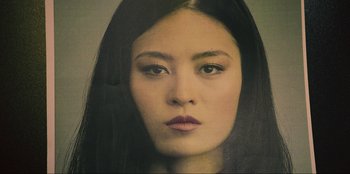 Movie still from “Sniper: G.R.I.T. - Global Response & Intelligence Team” (2023), directed by Oliver Thompson – A person with long hair; Close Up shot, Low angle