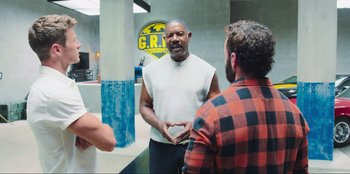 Movie still from “Sniper: G.R.I.T. - Global Response & Intelligence Team” (2023), directed by Oliver Thompson – A man talking to two other people in a room; Medium shot, Over the shoulder angle