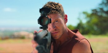 Movie still from “Sniper: G.R.I.T. - Global Response & Intelligence Team” (2023), directed by Oliver Thompson – A person holding a rifle; Close Up shot, High angle