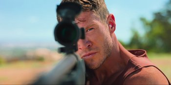 Movie still from “Sniper: G.R.I.T. - Global Response & Intelligence Team” (2023), directed by Oliver Thompson – A person with a rifle; Close Up shot, Low angle