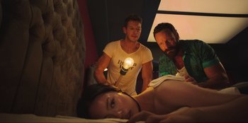 Movie still from “Sniper: G.R.I.T. - Global Response & Intelligence Team” (2023), directed by Oliver Thompson – A man and two women standing next to each other in a room; Medium shot, Low angle