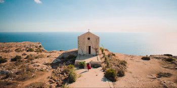 Movie still from “Sniper: G.R.I.T. - Global Response & Intelligence Team” (2023), directed by Oliver Thompson – A small church on a cliff overlooking the ocean; Extreme Wide shot, High angle