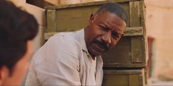 Movie still from “Sniper: G.R.I.T. - Global Response & Intelligence Team” (2023), directed by Oliver Thompson – An older man with a beard and a mustache; Close Up shot, Low angle