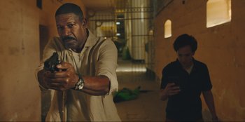 Movie still from “Sniper: G.R.I.T. - Global Response & Intelligence Team” (2023), directed by Oliver Thompson – A man holding a baseball bat while standing next to another man; Medium shot, Low angle