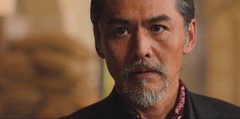 Movie still from “Sniper: G.R.I.T. - Global Response & Intelligence Team” (2023), directed by Oliver Thompson – A person with a beard; Close Up shot, Low angle