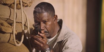 Movie still from “Sniper: G.R.I.T. - Global Response & Intelligence Team” (2023), directed by Oliver Thompson – A man holding a gun in his hand; Close Up shot, Low angle