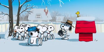 Movie still from “Snoopy Presents: For Auld Lang Syne” (2021), directed by Clay Kaytis – A group of dogs in the snow with a photographer; Extreme Wide shot, Low angle