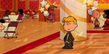 Movie still from “Snoopy Presents: For Auld Lang Syne” (2021), directed by Clay Kaytis – A boy in a suit standing in front of a stage; Extreme Wide shot, High angle