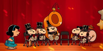 Movie still from “Snoopy Presents: For Auld Lang Syne” (2021), directed by Clay Kaytis – A group of peanuts sitting on top of a stage; Extreme Wide shot, High angle