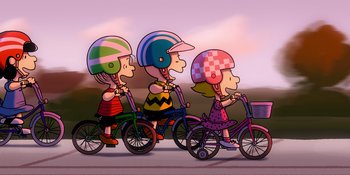 Movie still from “Snoopy Presents: Lucy's School” (2022), directed by Raymond S. Persi – A group of people riding bikes on a road; Extreme Wide shot, High angle