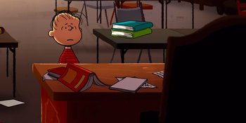 Movie still from “Snoopy Presents: Lucy's School” (2022), directed by Raymond S. Persi – A charlie brown character sitting in front of a table with books on top of it; Wide shot, High angle