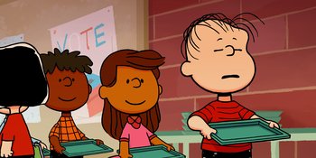 Movie still from “Snoopy Presents: One-of-a-Kind Marcie” (2023), directed by Raymond S. Persi – A group of children standing around each other in a classroom; Medium shot, High angle