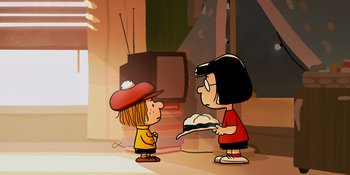 Movie still from “Snoopy Presents: One-of-a-Kind Marcie” (2023), directed by Raymond S. Persi – A cartoon of a girl and a boy in front of a television; Medium shot, High angle