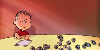 Movie still from “Snoopy Presents: To Mom (and Dad), with Love” (2022), directed by Clay Kaytis – A child sitting at a table in front of a pile of paper; Medium shot, High angle
