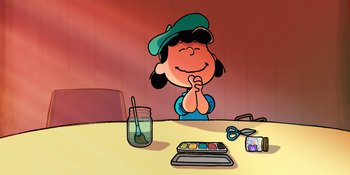Movie still from “Snoopy Presents: To Mom (and Dad), with Love” (2022), directed by Clay Kaytis – A girl sitting at a table with a paint set; Medium shot, High angle