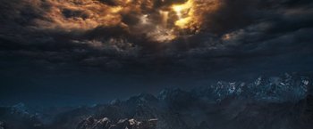 The sun is shining through the clouds on a dark night